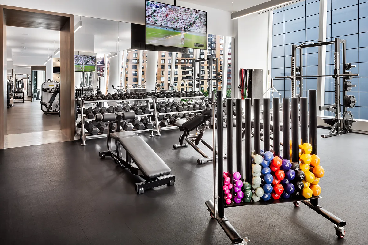50 West Street, Unit 30B Manhattan, NY 10006 - Photo 21 of 25 a room with lots of gym equipment and a large window