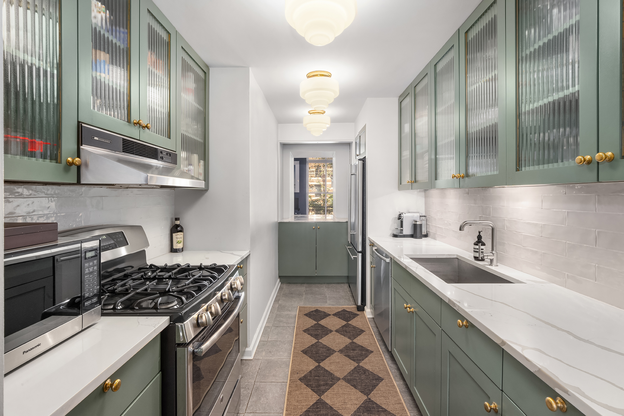 430 West 23rd Street, Unit C Manhattan, NY 10011 - Photo 8 of 16 a kitchen with a sink stove top oven and cabinets