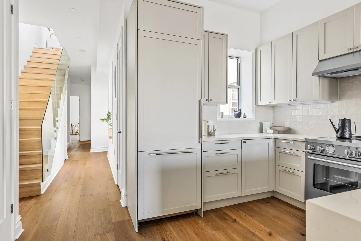 a kitchen with cabinets appliances and wooden floor