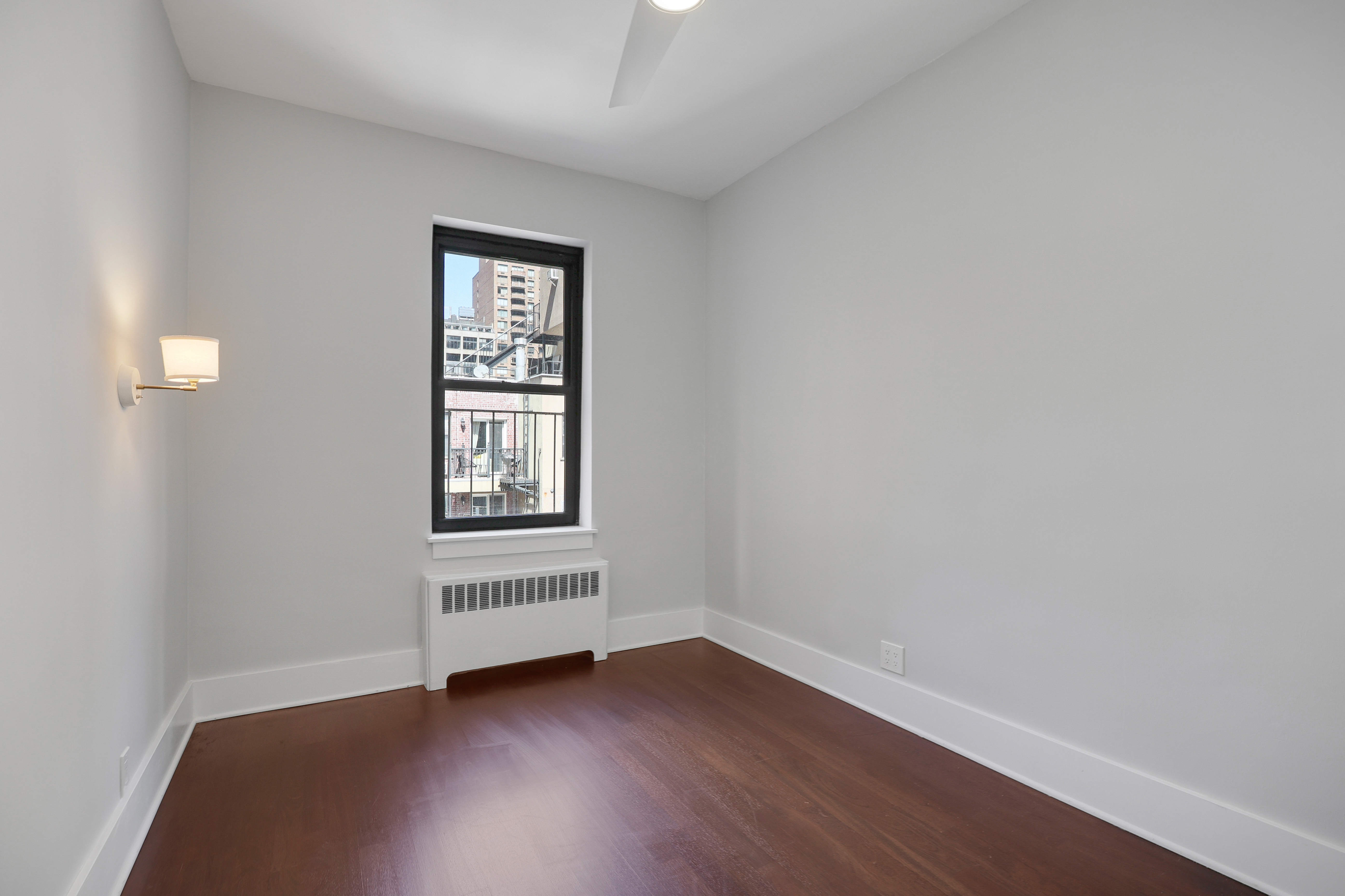 133 East 30th Street, Unit PH5B Manhattan, NY 10016 - Photo 18 of 24 a view of an empty room with wooden floor and a window