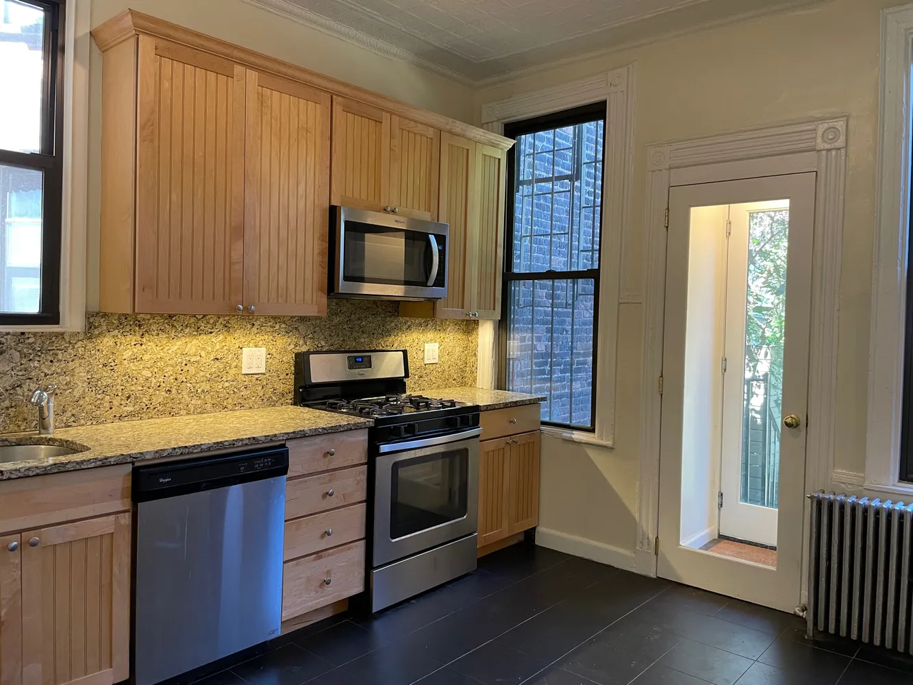 a kitchen with stainless steel appliances granite countertop a stove a sink and a microwave