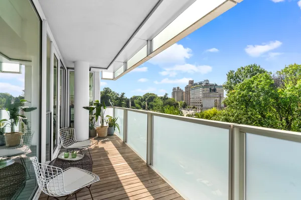 a balcony with furniture and a potted plant