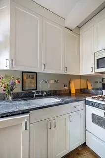 a kitchen with granite countertop white cabinets and white appliances