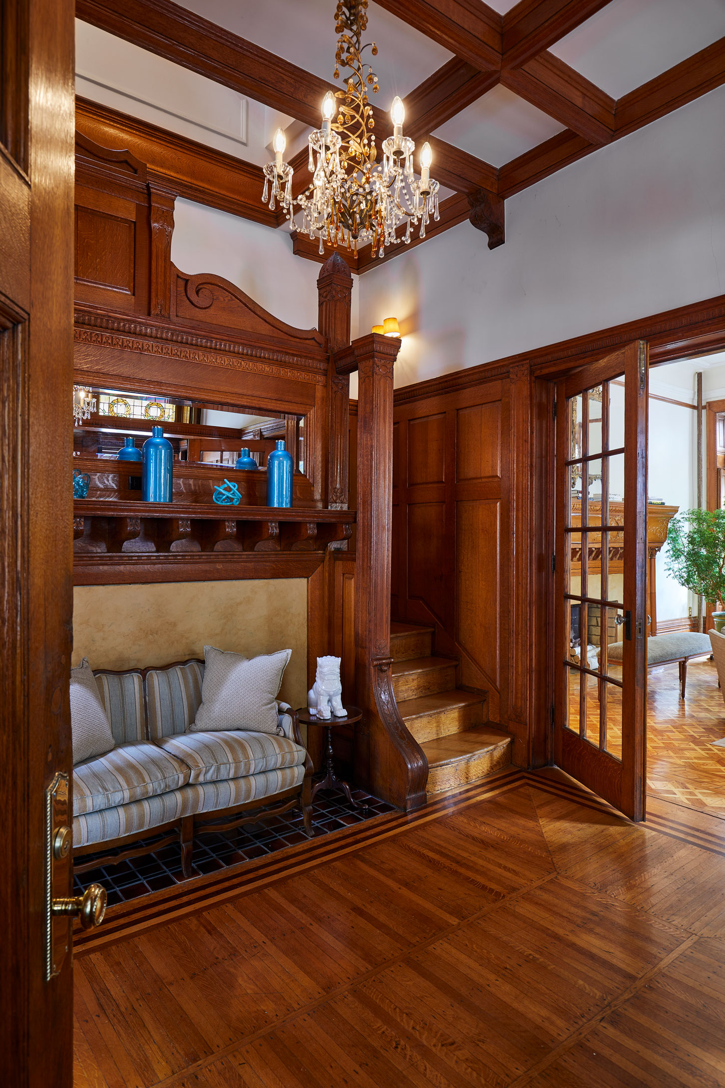 320 Convent Avenue Manhattan, NY 10031 - Photo 3 of 15 a living room with hardwood floor a ceiling fan a fireplace and a chandelier