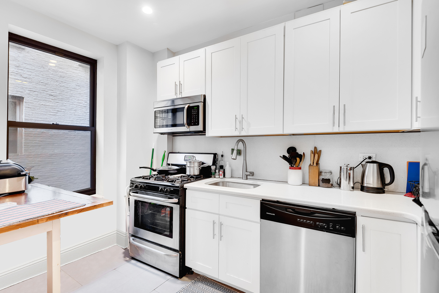 750 Riverside Drive, Unit 3E Manhattan, NY 10031 - Photo 6 of 8 a kitchen with granite countertop white cabinets and white appliances