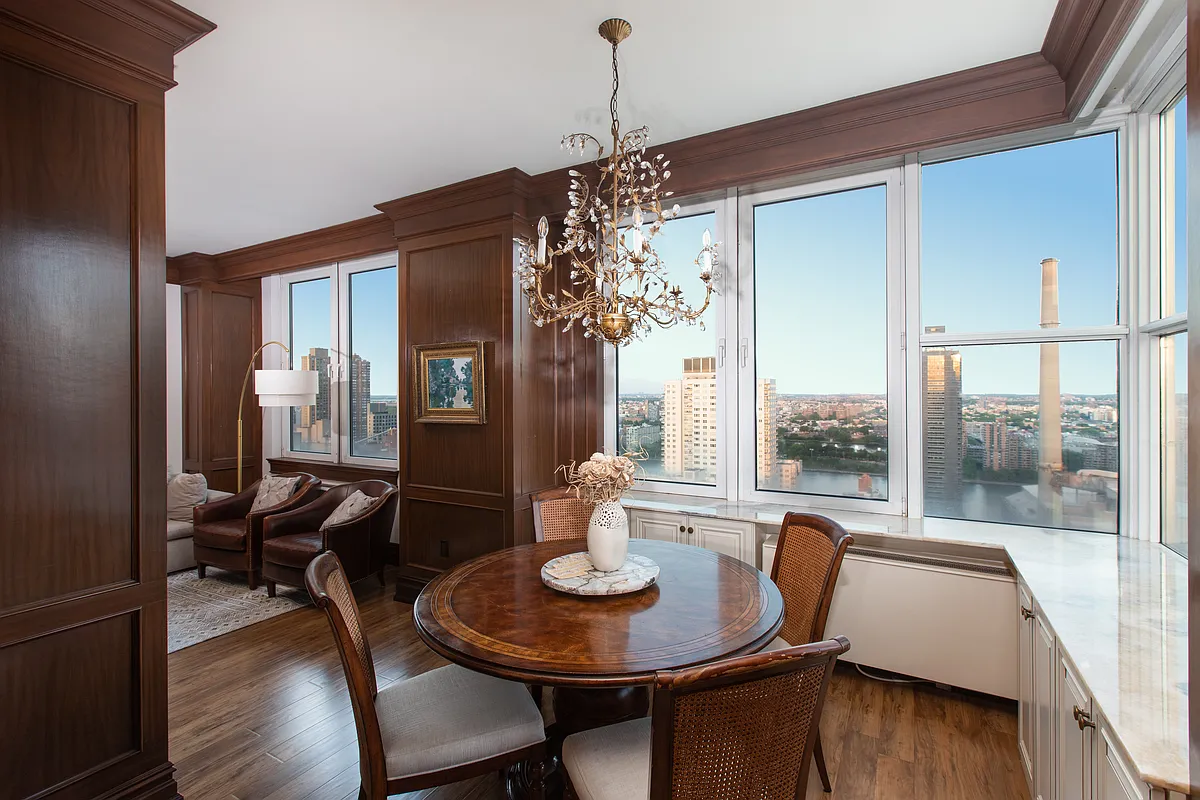 404 East 76th Street, Unit 30C Manhattan, NY 10021 - Photo 4 of 24 a view of a dining room with furniture wooden floor and a chandelier