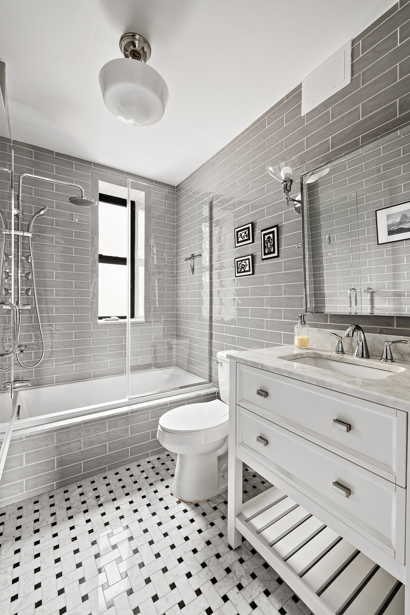 163 Ocean Avenue, Unit G6 Brooklyn, NY 11225 - Photo 6 of 12 a bathroom with a sink a toilet a mirror a vanity a bathtub and shower