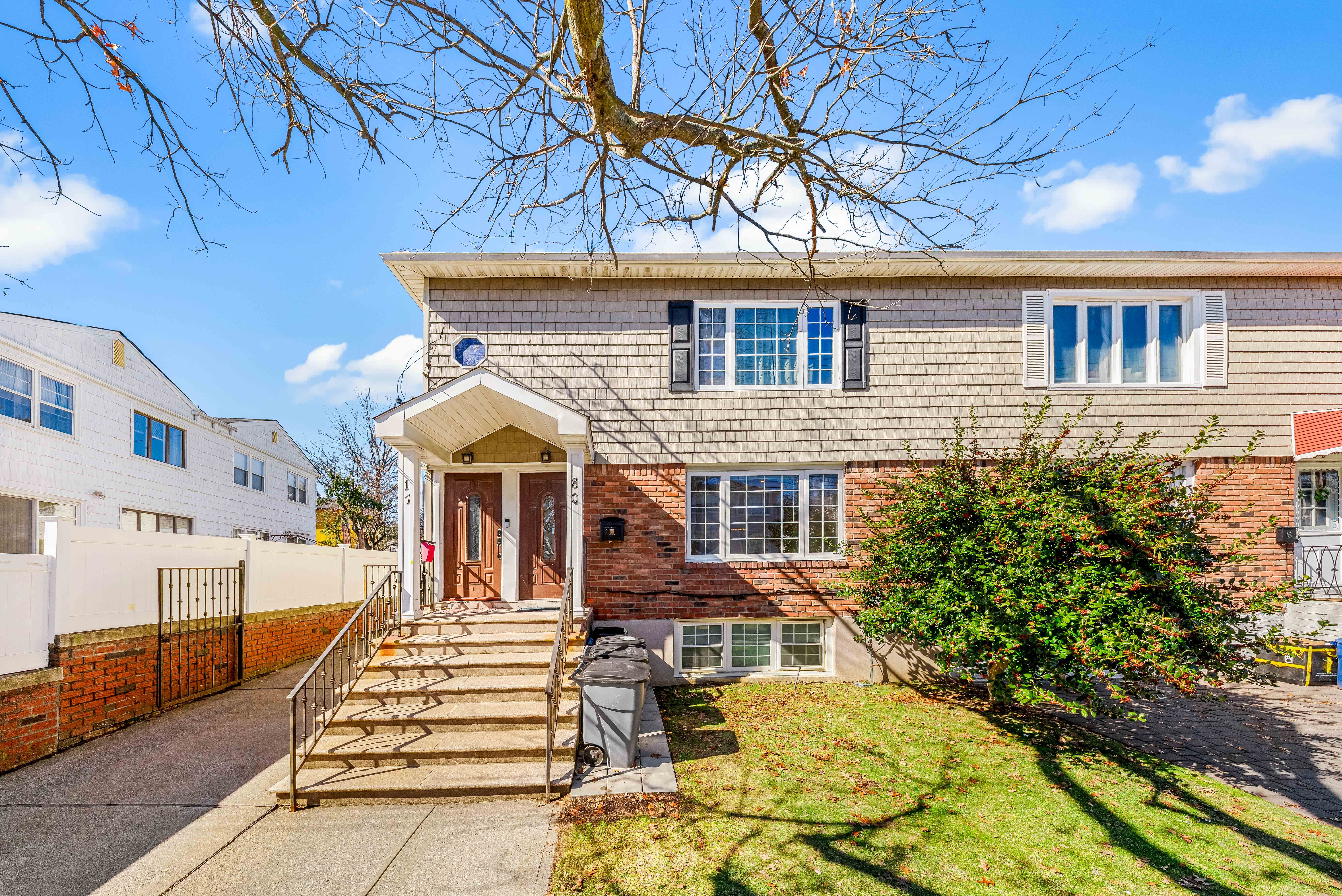 15-80 209th Street, Unit 2 Queens, NY 11360 - Photo 16 of 21 a front view of a house with a yard