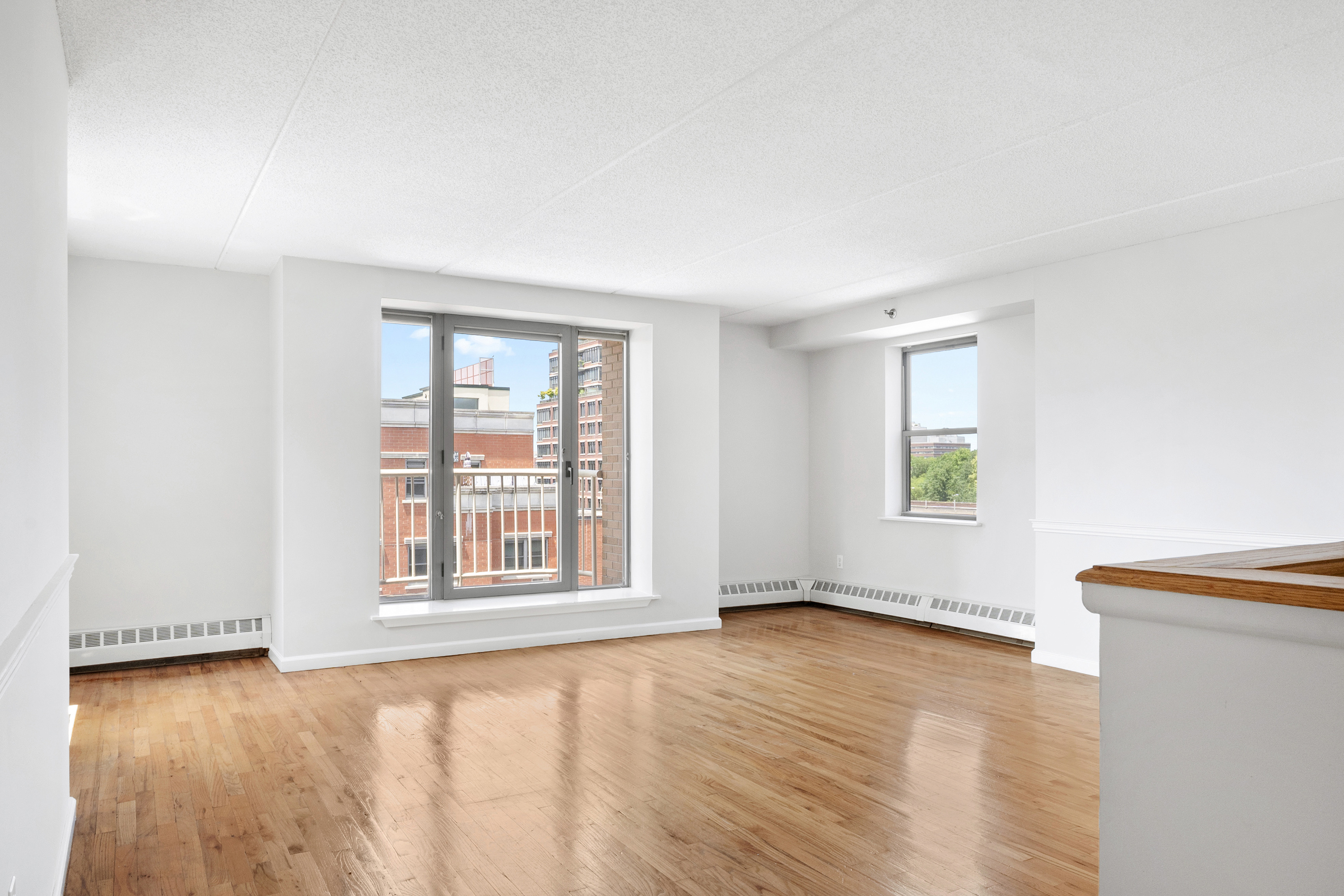 1825 Madison Avenue, Unit 9H Manhattan, NY 10035 - Photo 1 of 10 an empty room with wooden floor and windows