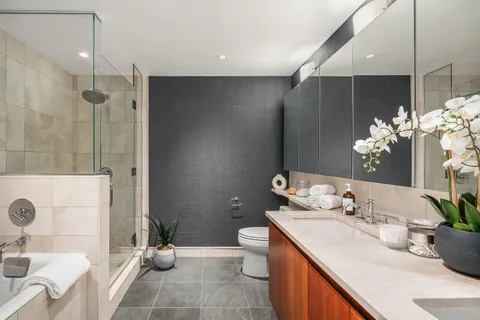 a bathroom with a granite countertop sink a toilet and shower