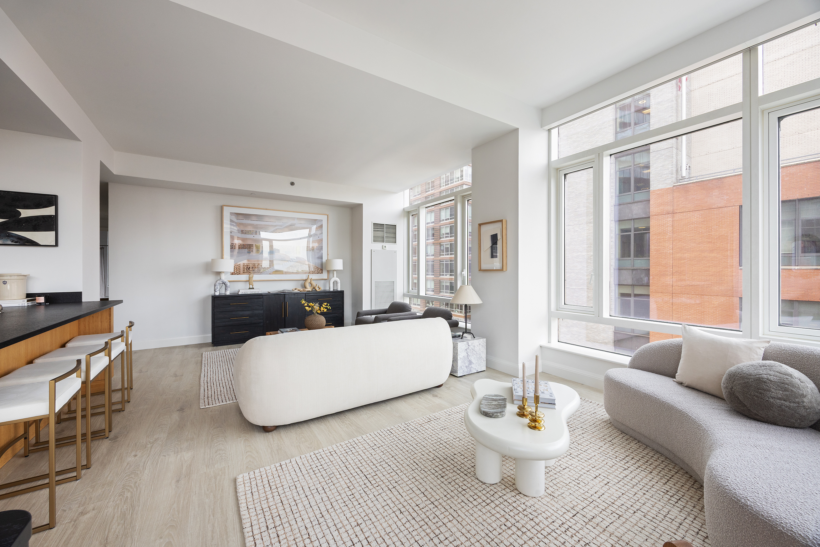70 Little West Street, Unit 7L Manhattan, NY 10004 - Photo 6 of 25 a living room with furniture a table and a large window