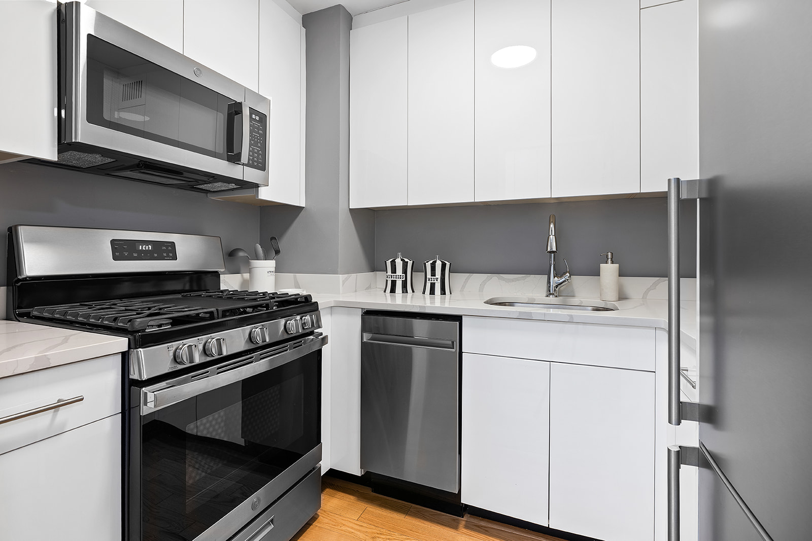 7 East 14th Street, Unit 429 Manhattan, NY 10003 - Photo 3 of 6 a kitchen with stainless steel appliances granite countertop white cabinets a stove a sink and dishwasher