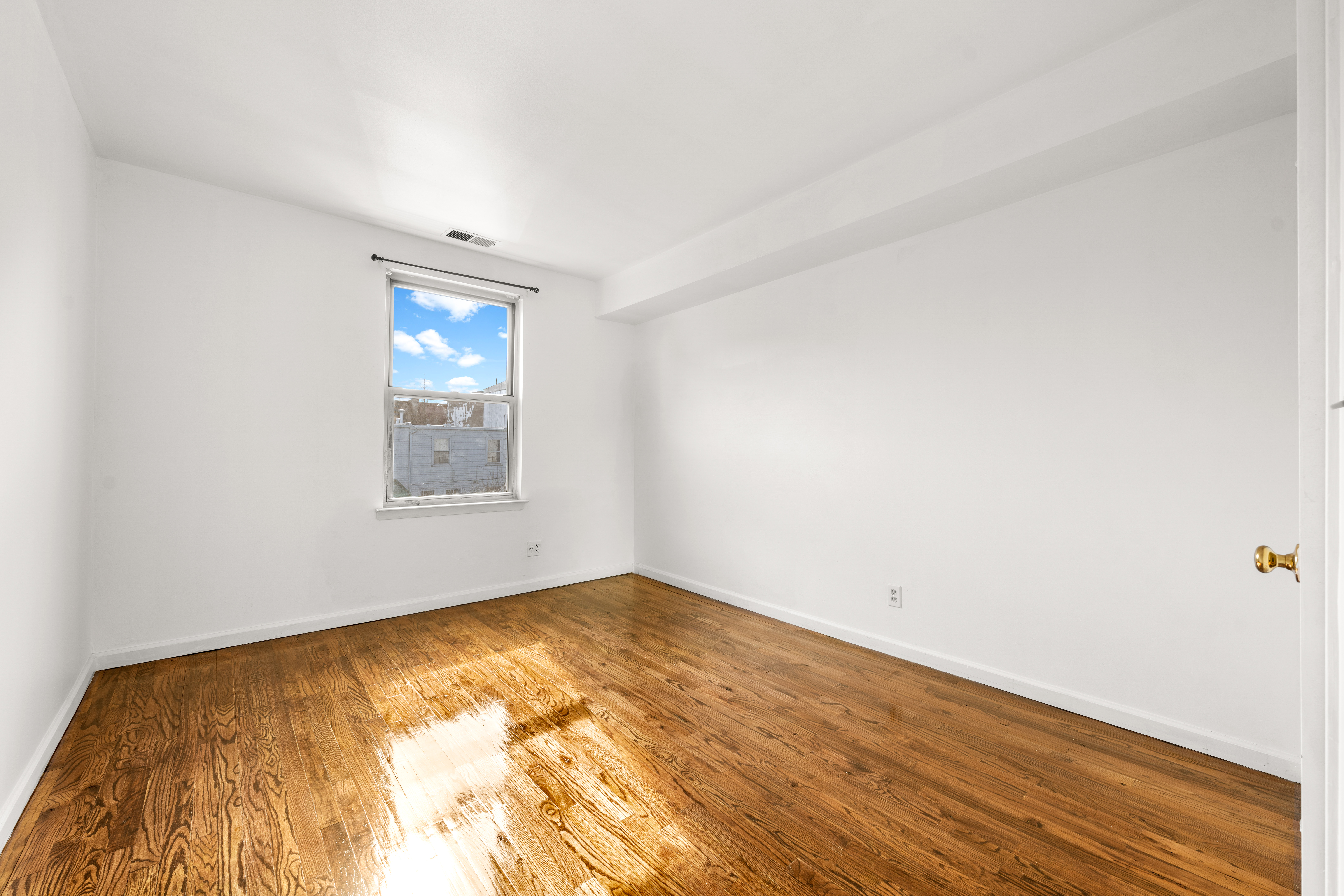 1050 Dekalb Avenue, Unit 2 Brooklyn, NY 11221 - Photo 5 of 10 an empty room with wooden floor and windows
