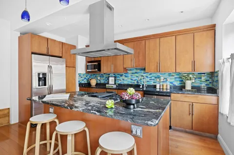 a kitchen with stainless steel appliances granite countertop a stove a sink and a dining table