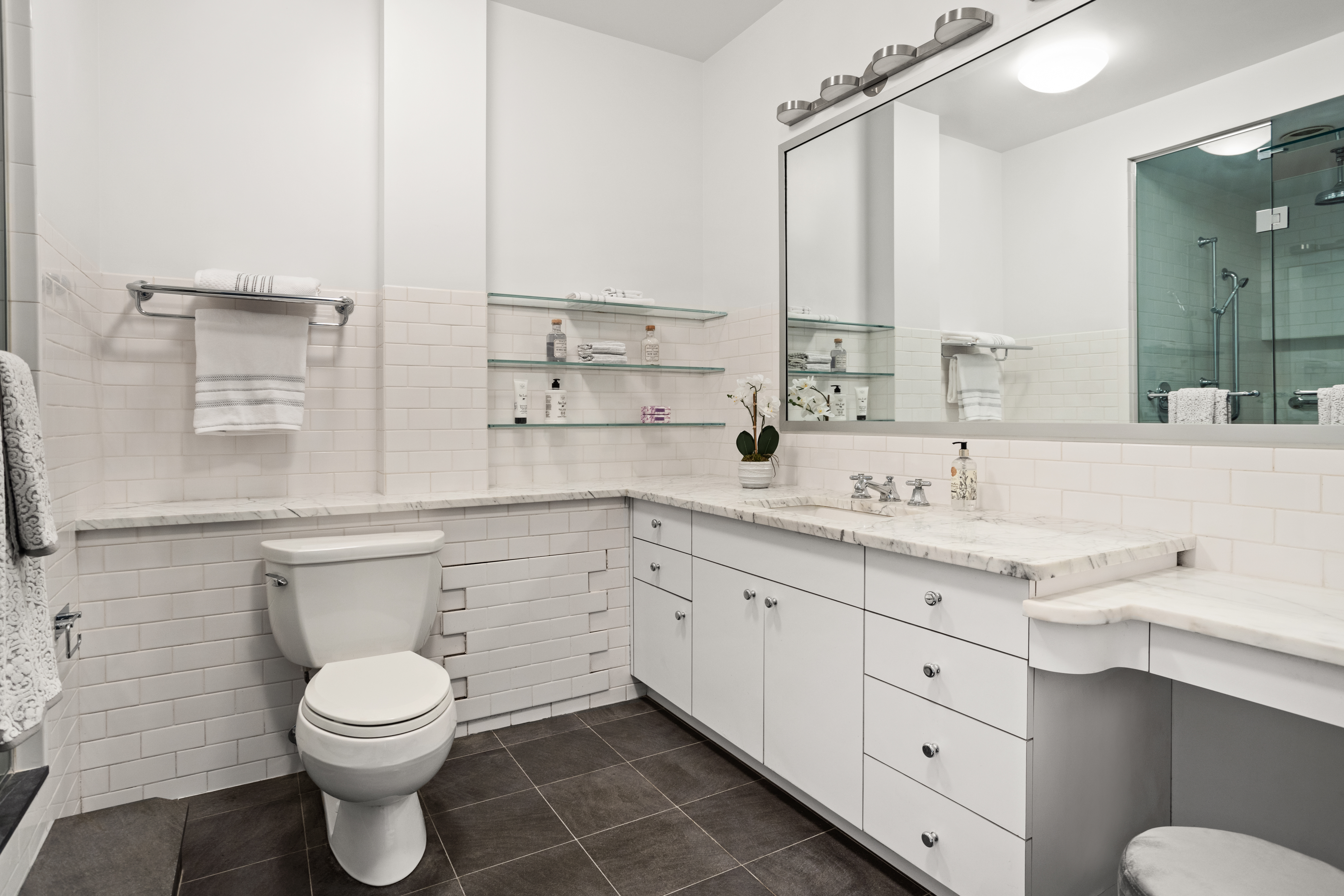 2 5th Avenue, Unit PHDF Manhattan, NY 10011 - Photo 9 of 24 a bathroom with a granite countertop toilet sink and mirror