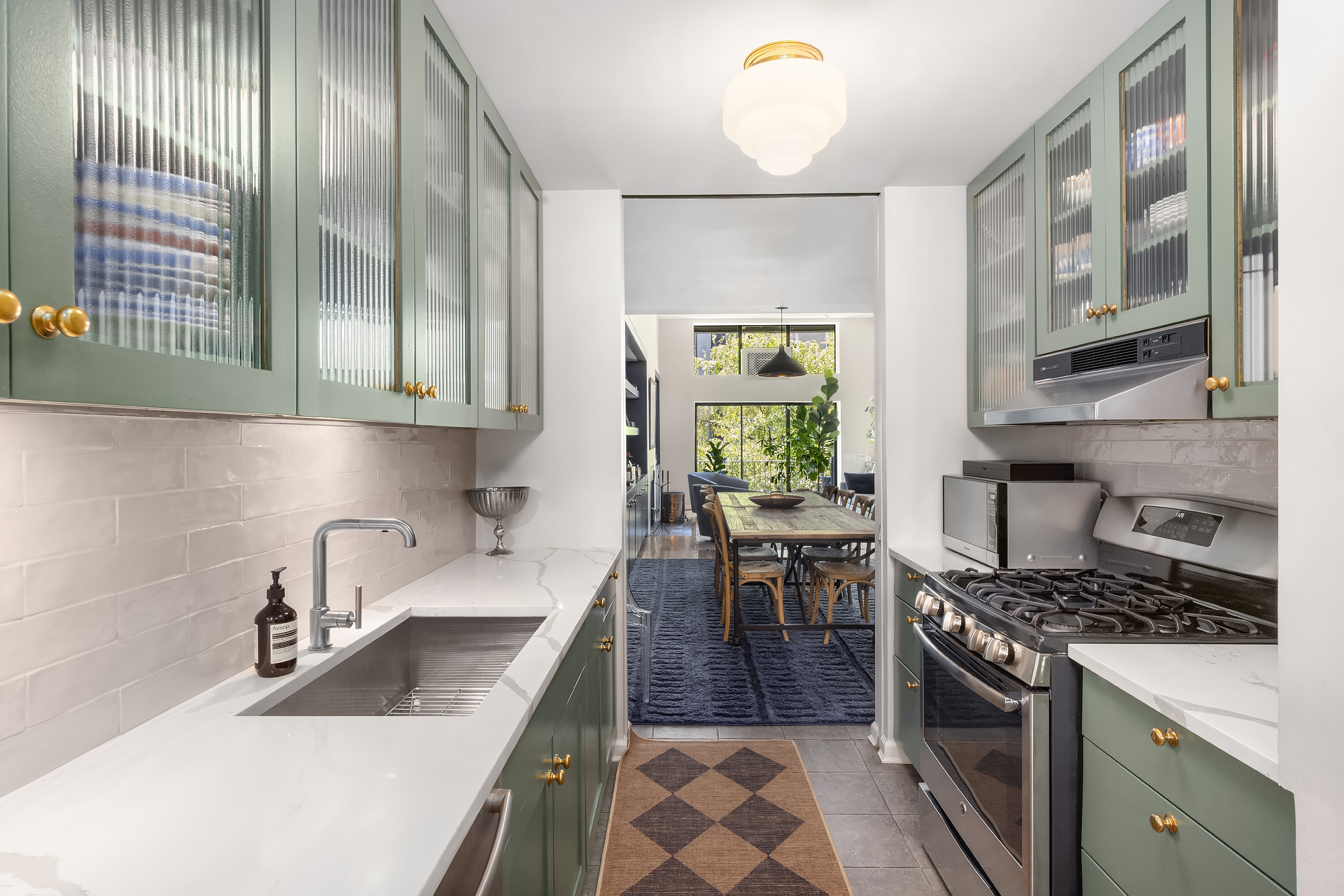 430 West 23rd Street, Unit C Manhattan, NY 10011 - Photo 9 of 16 a kitchen with a sink stove and cabinets