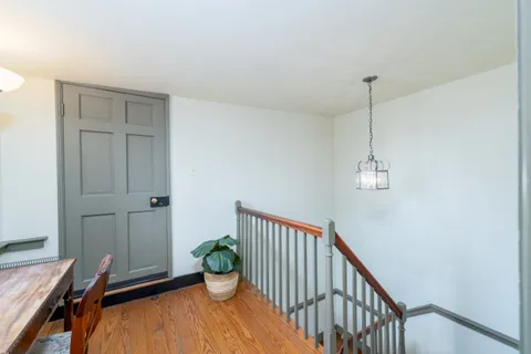 a view of entryway and hall with wooden floor