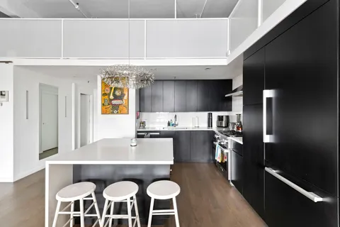 a kitchen with a table chairs refrigerator and microwave