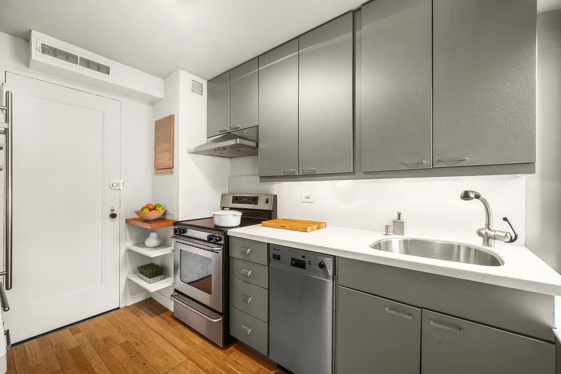 25 East 83rd Street, Unit 9B Manhattan, NY 10028 - Photo 4 of 8 a kitchen with stainless steel appliances a sink stove and refrigerator
