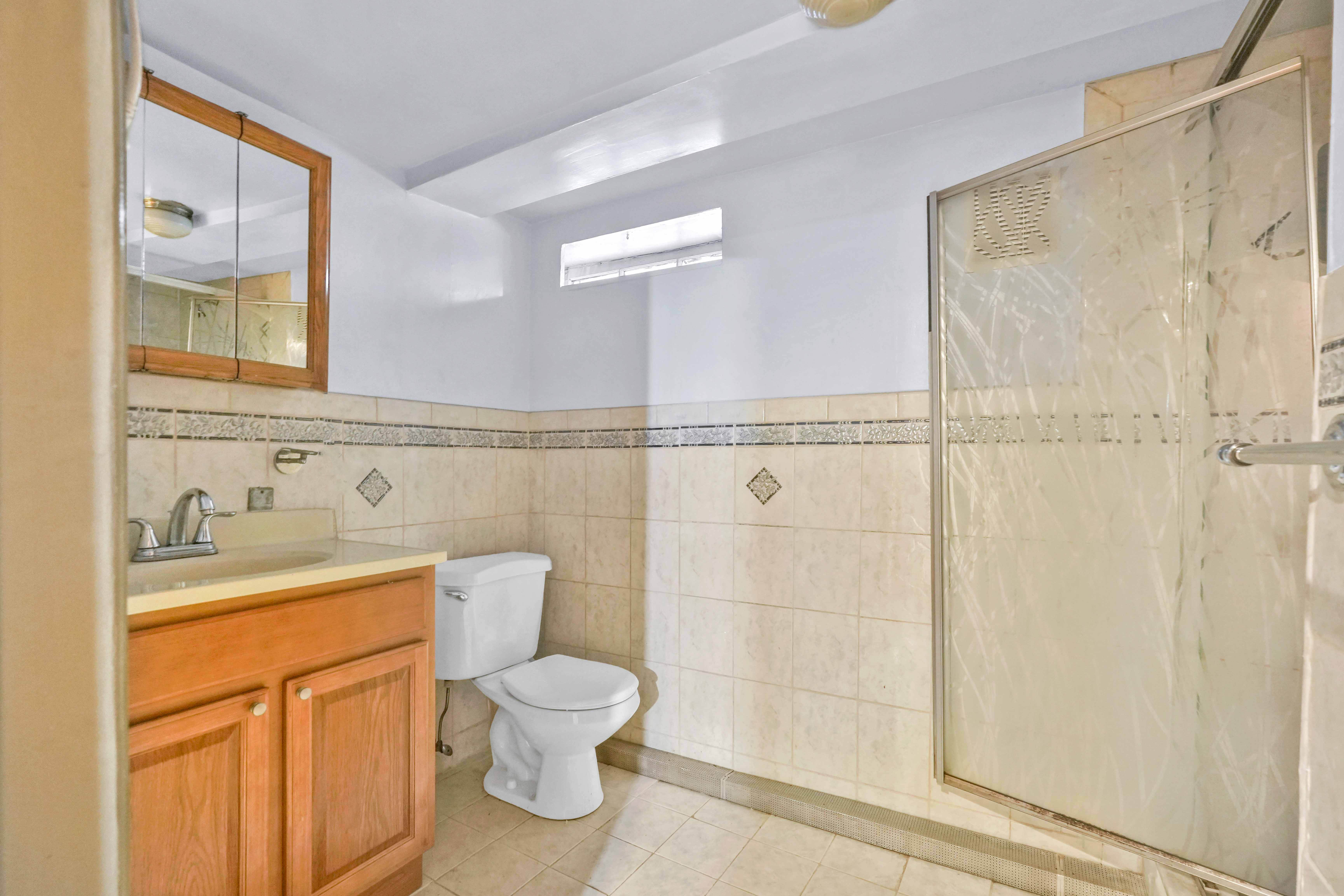 642 East 26th Street Brooklyn, NY 11210 - Photo 18 of 32 a bathroom with a toilet a sink and a shower