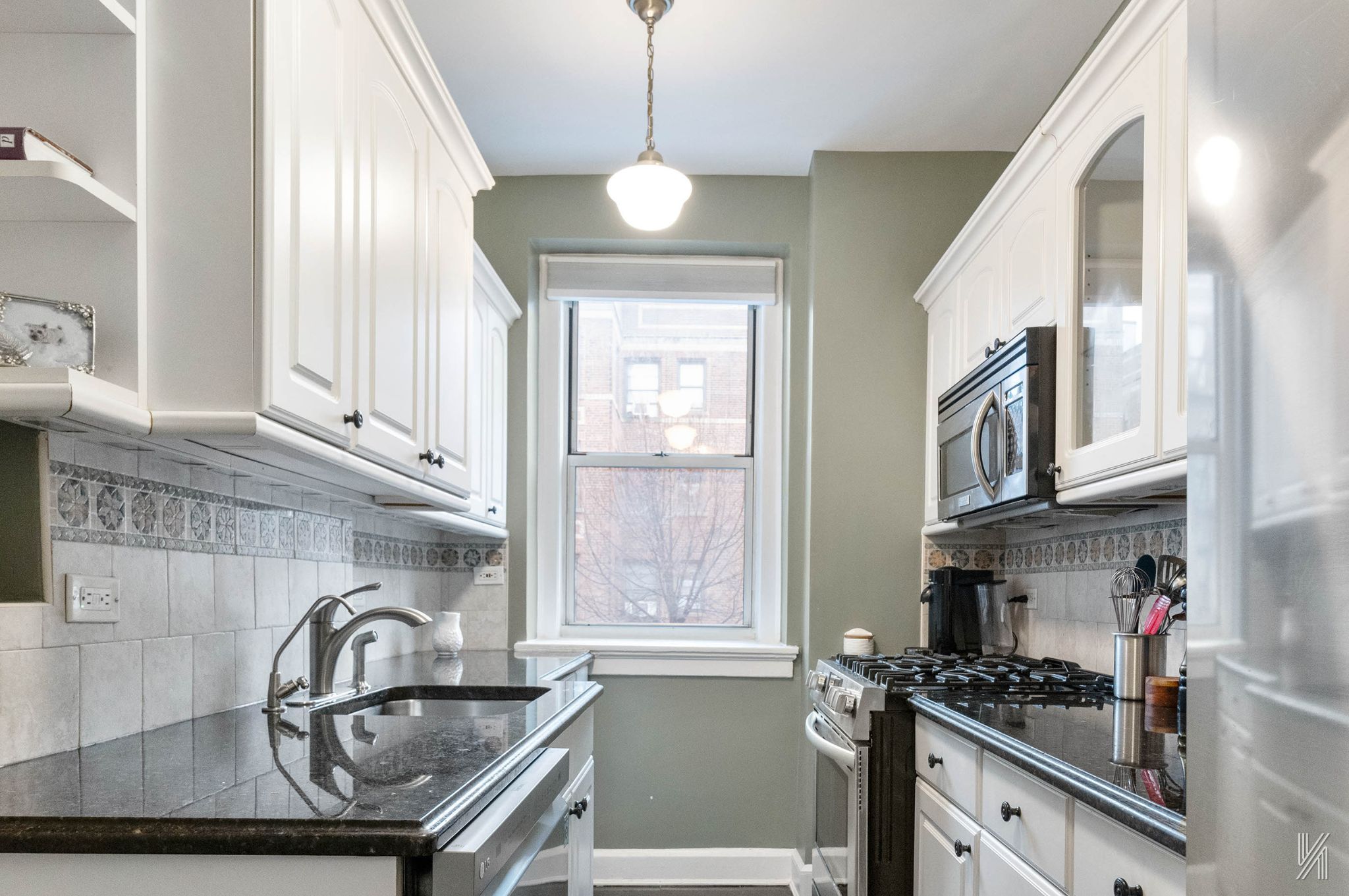 37-22 80th Street, Unit 31 Queens, NY 11372 - Photo 10 of 21 a kitchen with stainless steel appliances granite countertop a sink a stove and a window