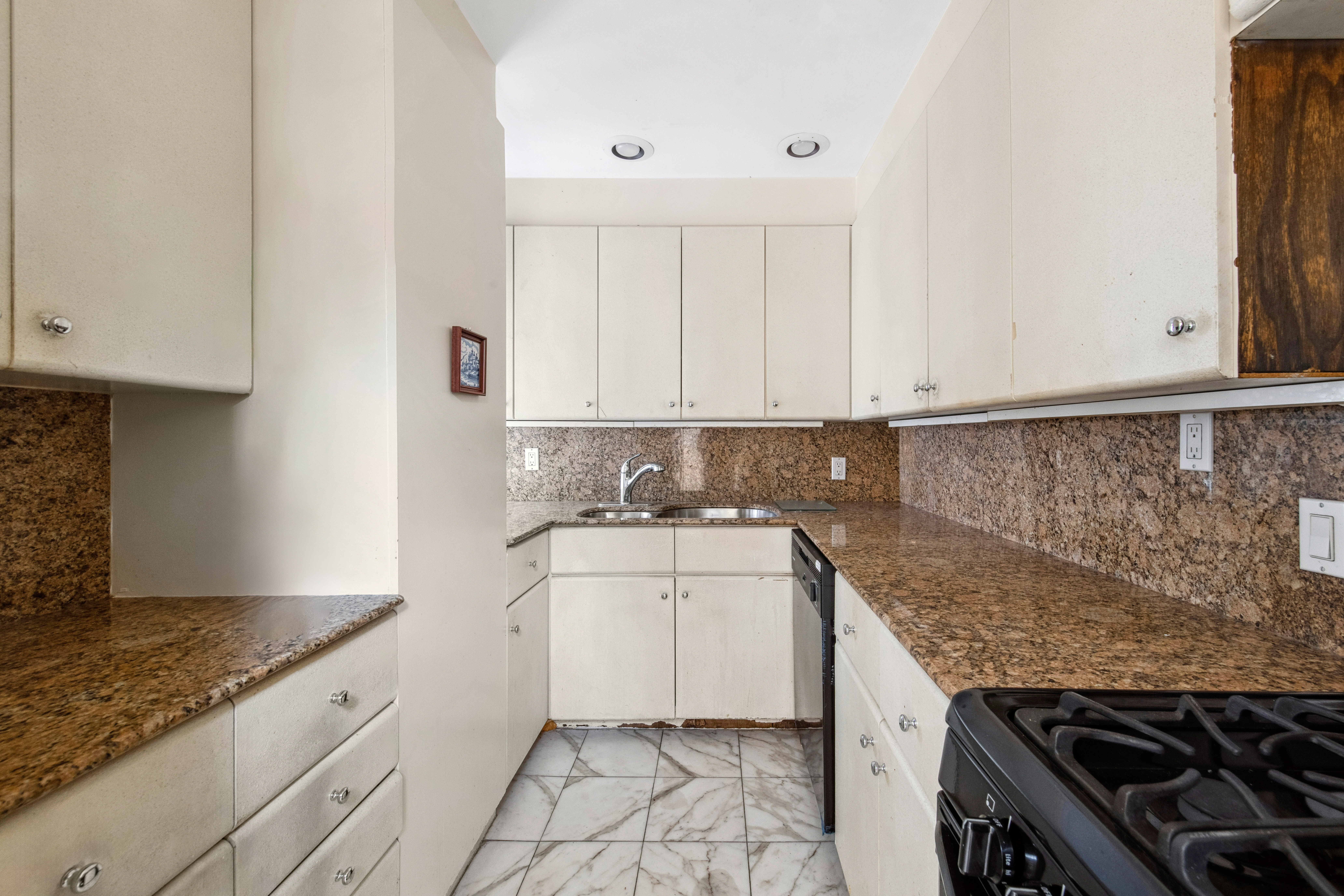 2 Sutton Place South, Unit 7F Manhattan, NY 10022 - Photo 5 of 18 a kitchen with granite countertop a sink stove and cabinets