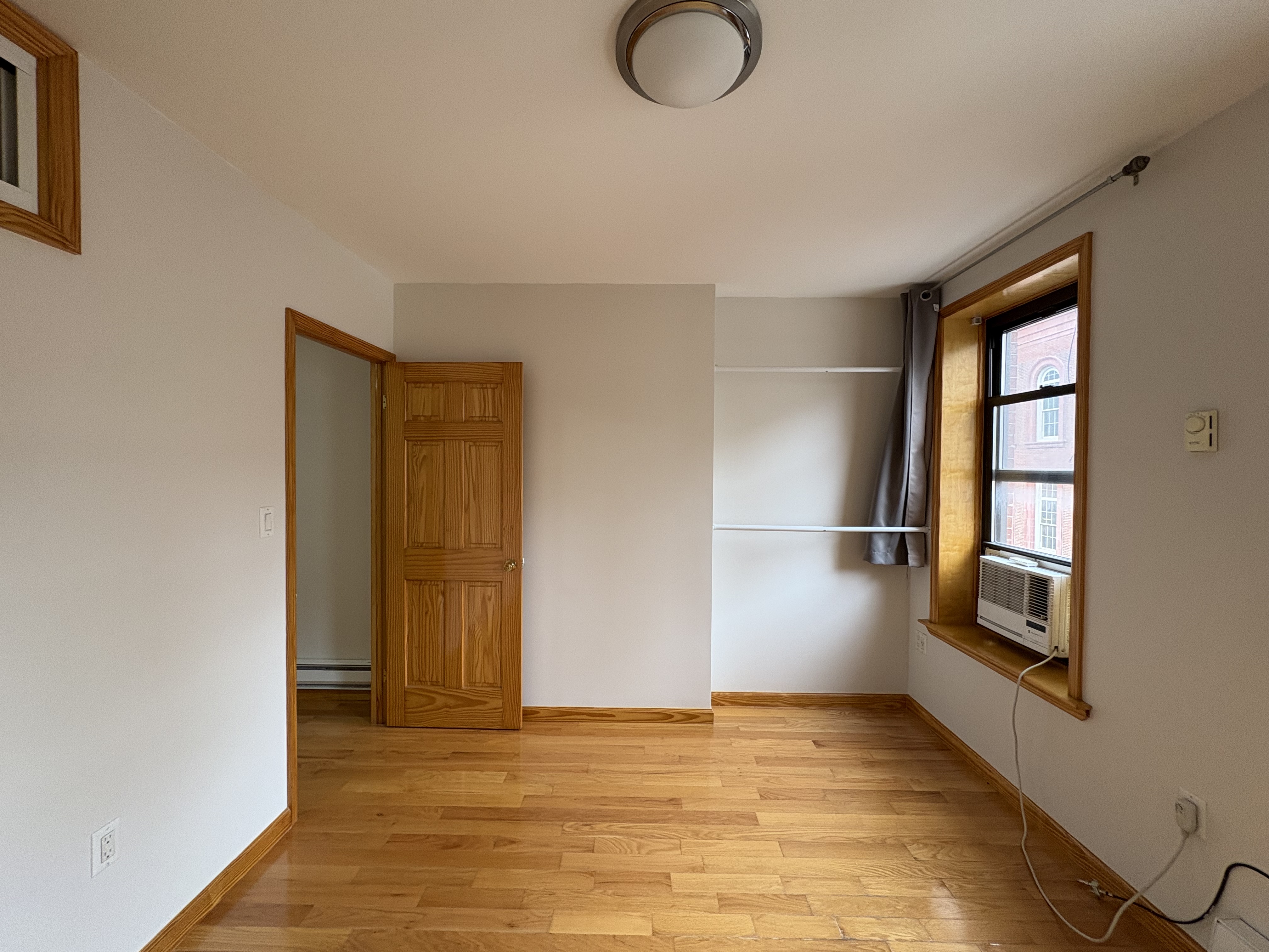 38 Ludlow Street, Unit 15 Manhattan, NY 10002 - Photo 3 of 16 a view of an empty room with window and wooden floor
