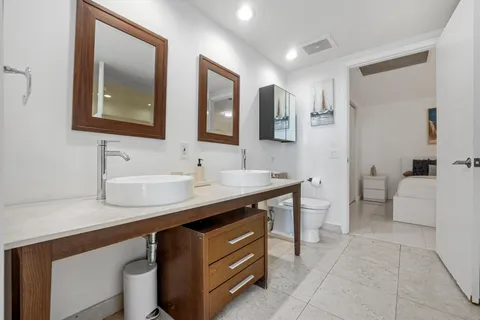 a bathroom with a sink a toilet and mirror