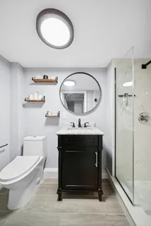 a bathroom with a toilet a sink and mirror