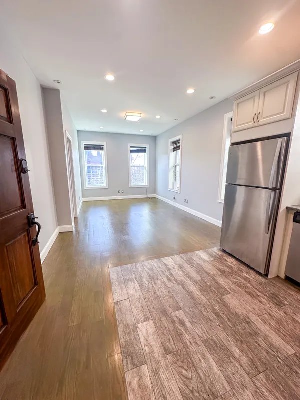 a view of empty room with wooden floor and window