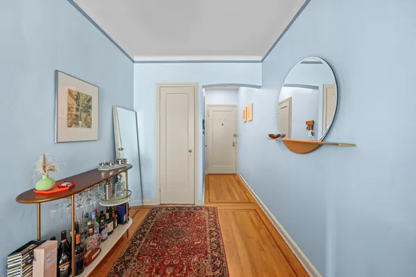 a view of a hallway with wooden floor and staircase