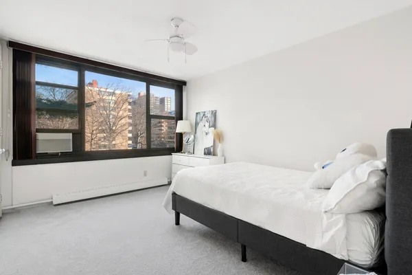 a bed sitting in a bedroom next to a large window