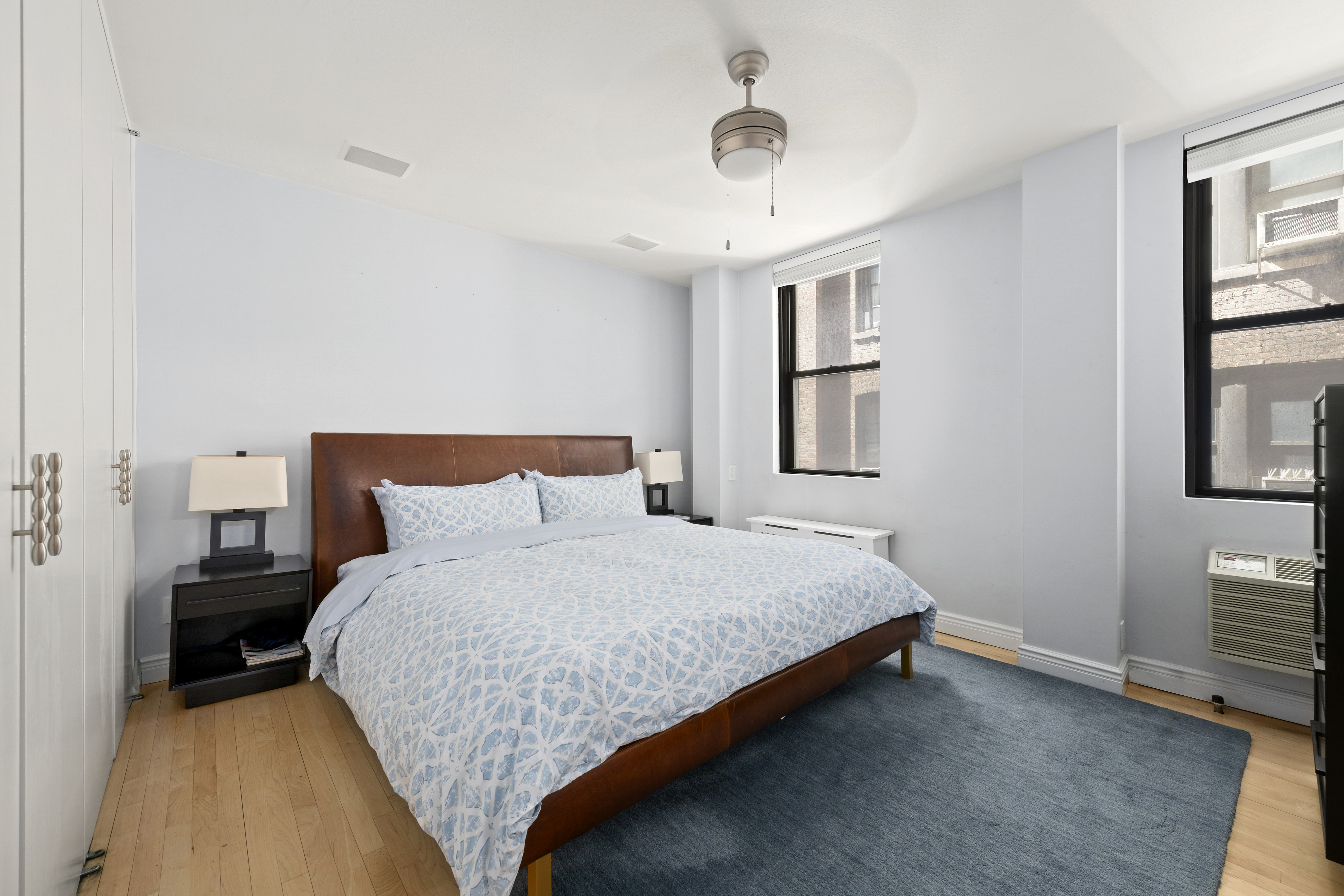 340 West 55th Street, Unit 5C Manhattan, NY 10019 - Photo 4 of 10 a bedroom with a bed and a night stand