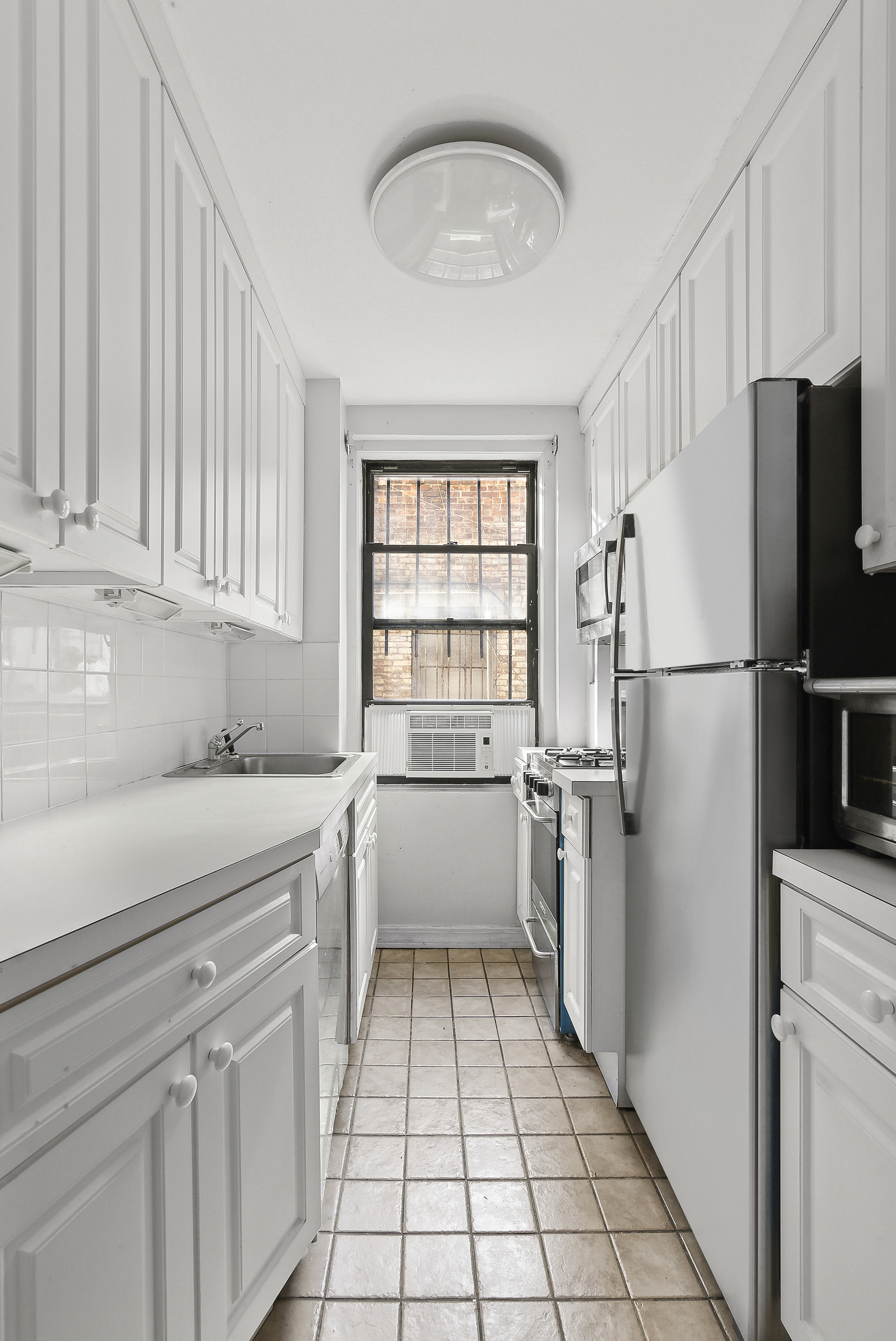 235 East 73rd Street, Unit 1D Manhattan, NY 10021 - Photo 5 of 13 a kitchen with a refrigerator and a sink
