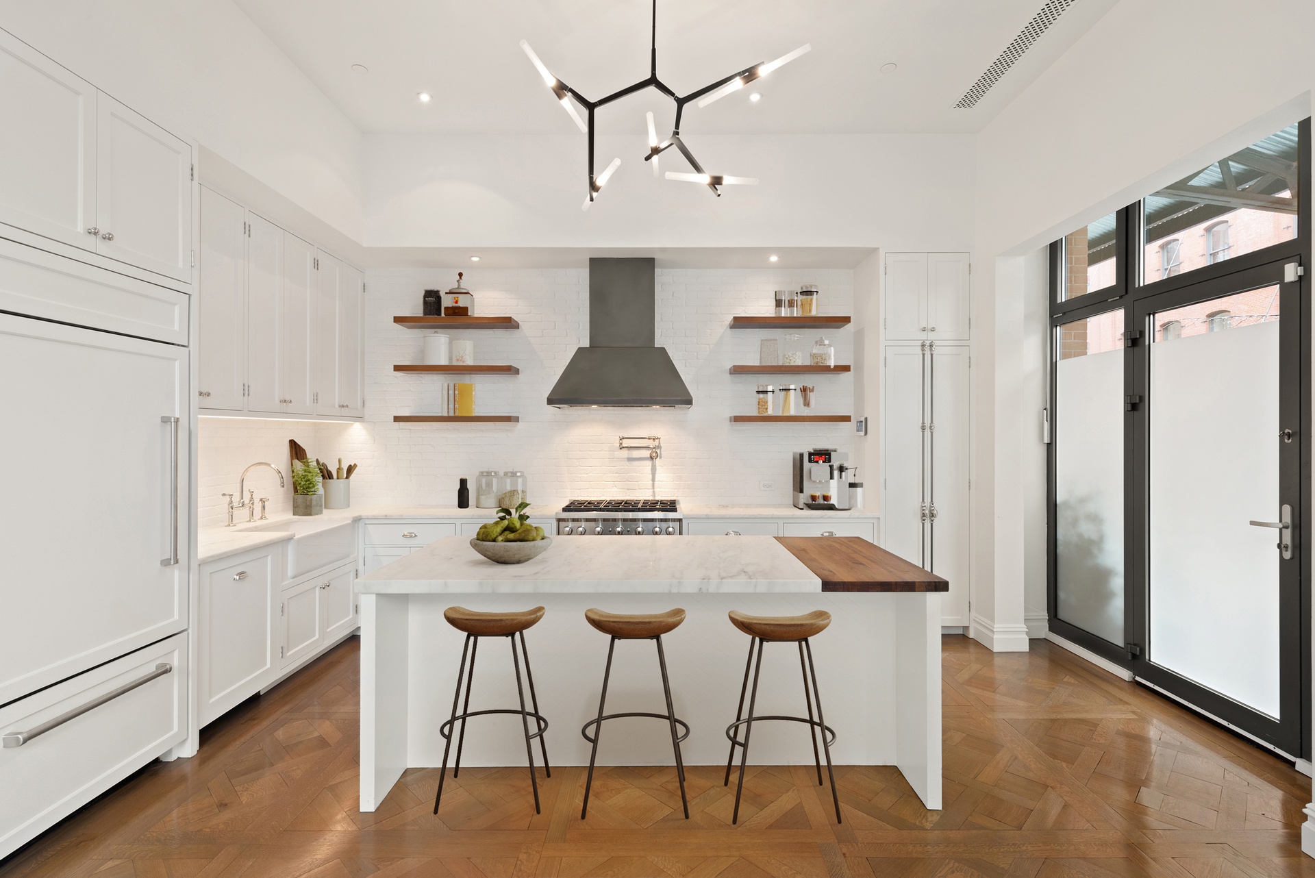 415 Washington Street, Unit 1B Manhattan, NY 10013 - Photo 4 of 16 a kitchen with stainless steel appliances a table and chairs in it
