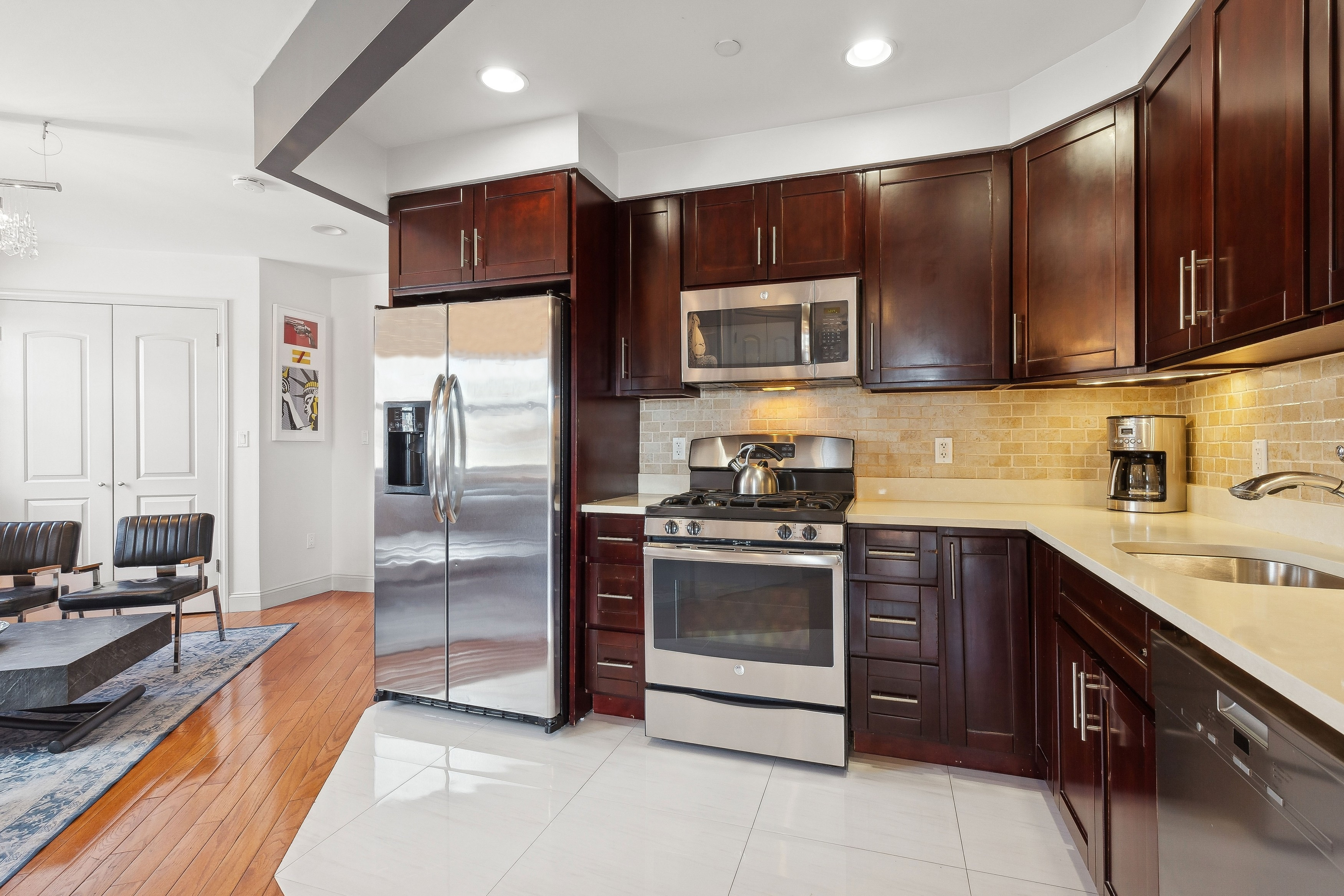 456 West 167th Street, Unit 7C Manhattan, NY 10032 - Photo 6 of 16 a kitchen with stainless steel appliances wooden cabinets and a stove top oven
