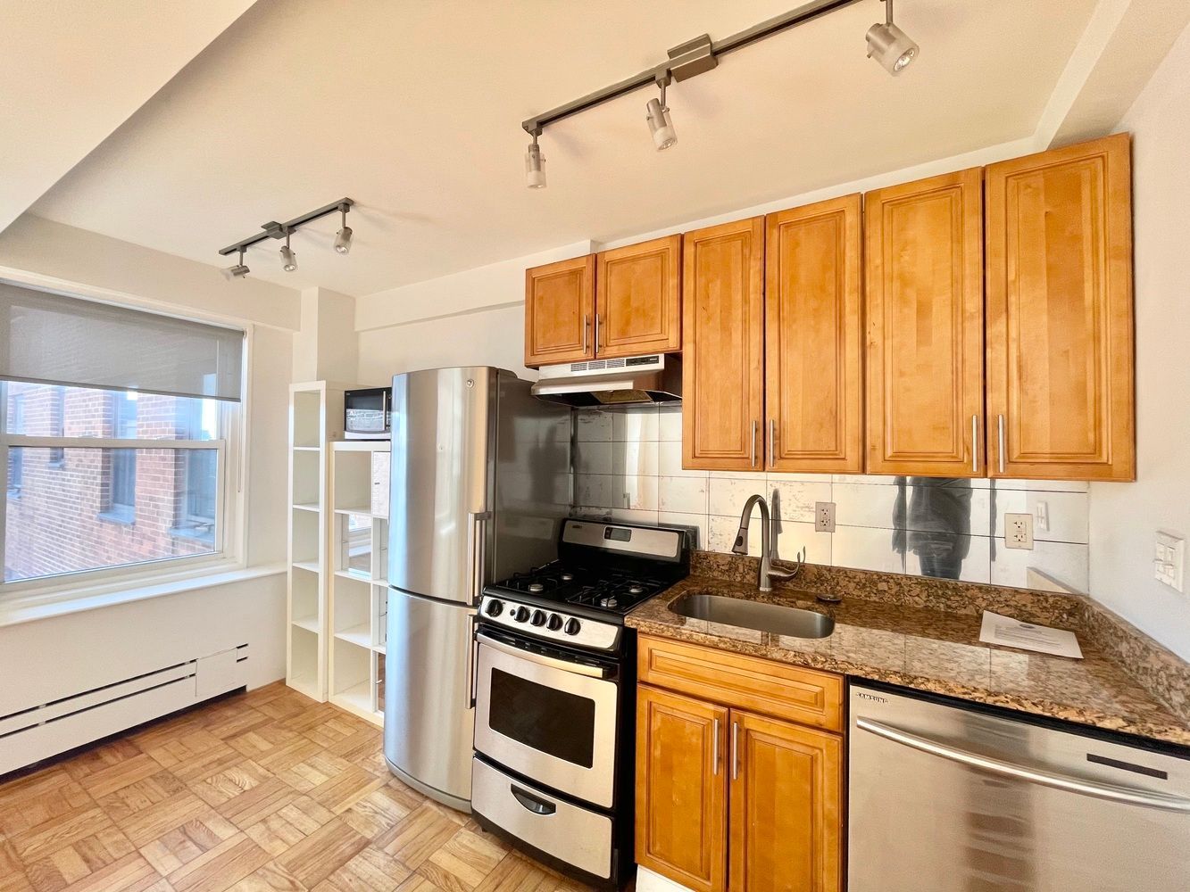 345 West 145th Street, Unit 8A1 Manhattan, NY 10031 - Photo 4 of 7 a kitchen with stainless steel appliances granite countertop a stove a sink and a refrigerator