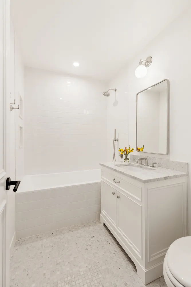 a bathroom with a granite countertop sink a toilet and bathtub