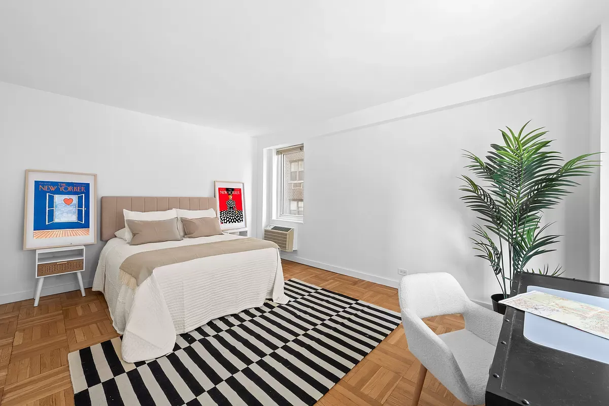 a spacious bedroom with a bed and a potted plant