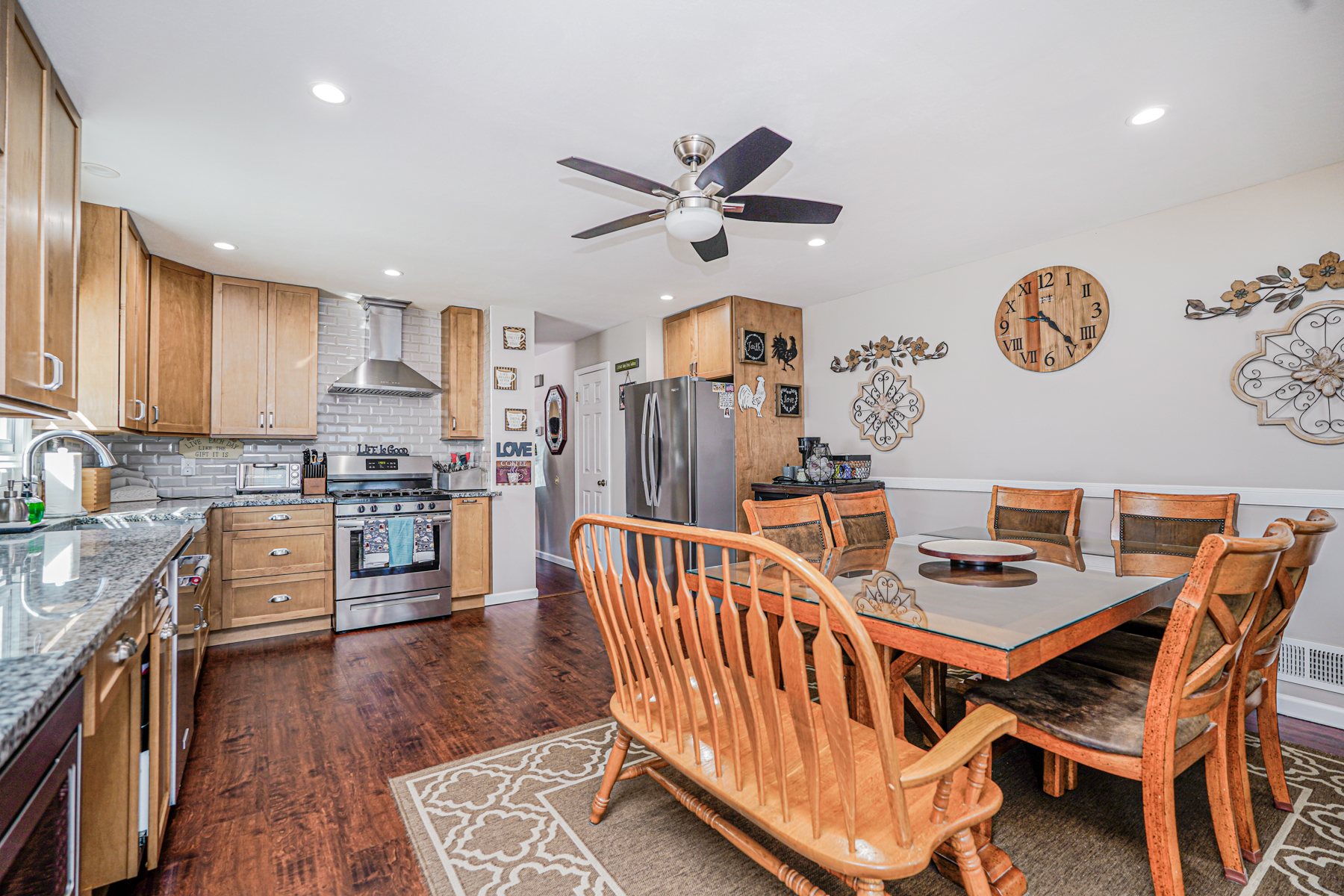 287 Greaves Avenue Staten Island, NY 10308 - Photo 10 of 35 a kitchen with stainless steel appliances granite countertop a refrigerator a stove a sink a dining table and chairs with wooden floor