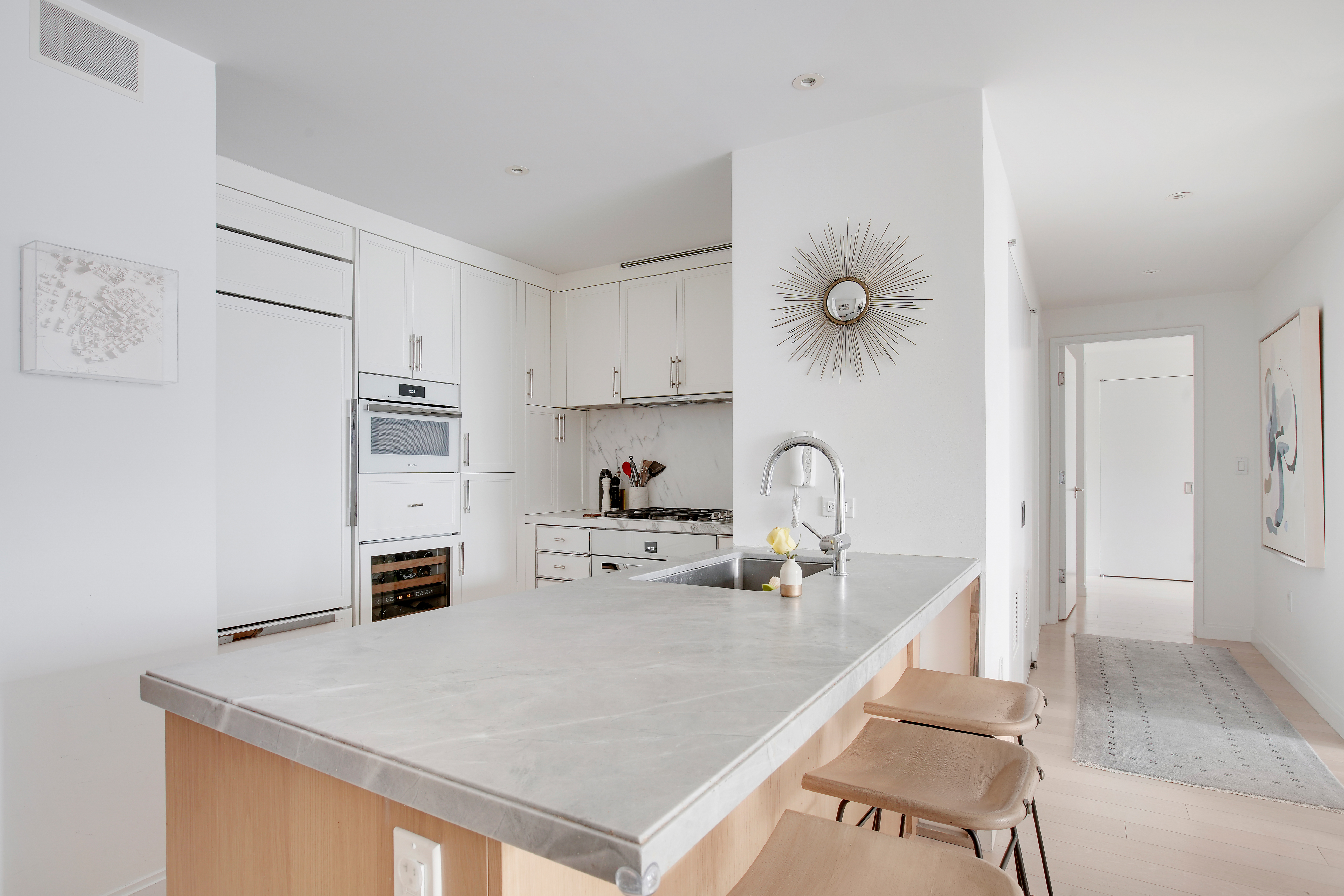 212 Warren Street, Unit 17S Manhattan, NY 10282 - Photo 5 of 15 a kitchen with kitchen island a sink appliances and cabinets