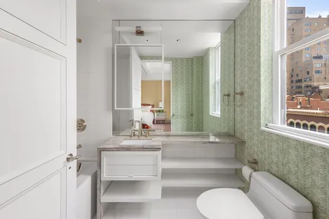 a bathroom with a toilet a sink and a mirror