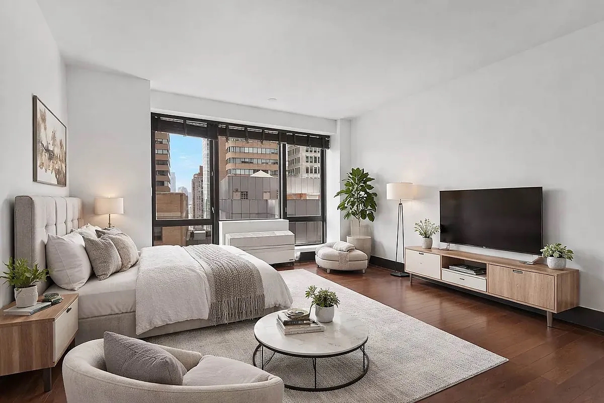 40 Broad Street, Unit 25C Manhattan, NY 10004 - Photo 1 of 10 a living room with furniture and a flat screen tv