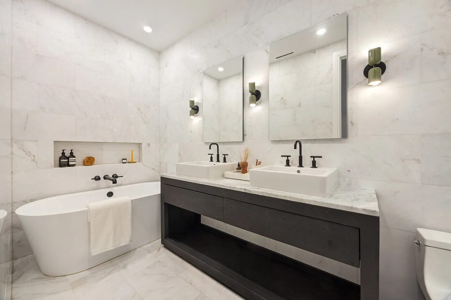 a bathroom with a double vanity sink mirror and bathtub
