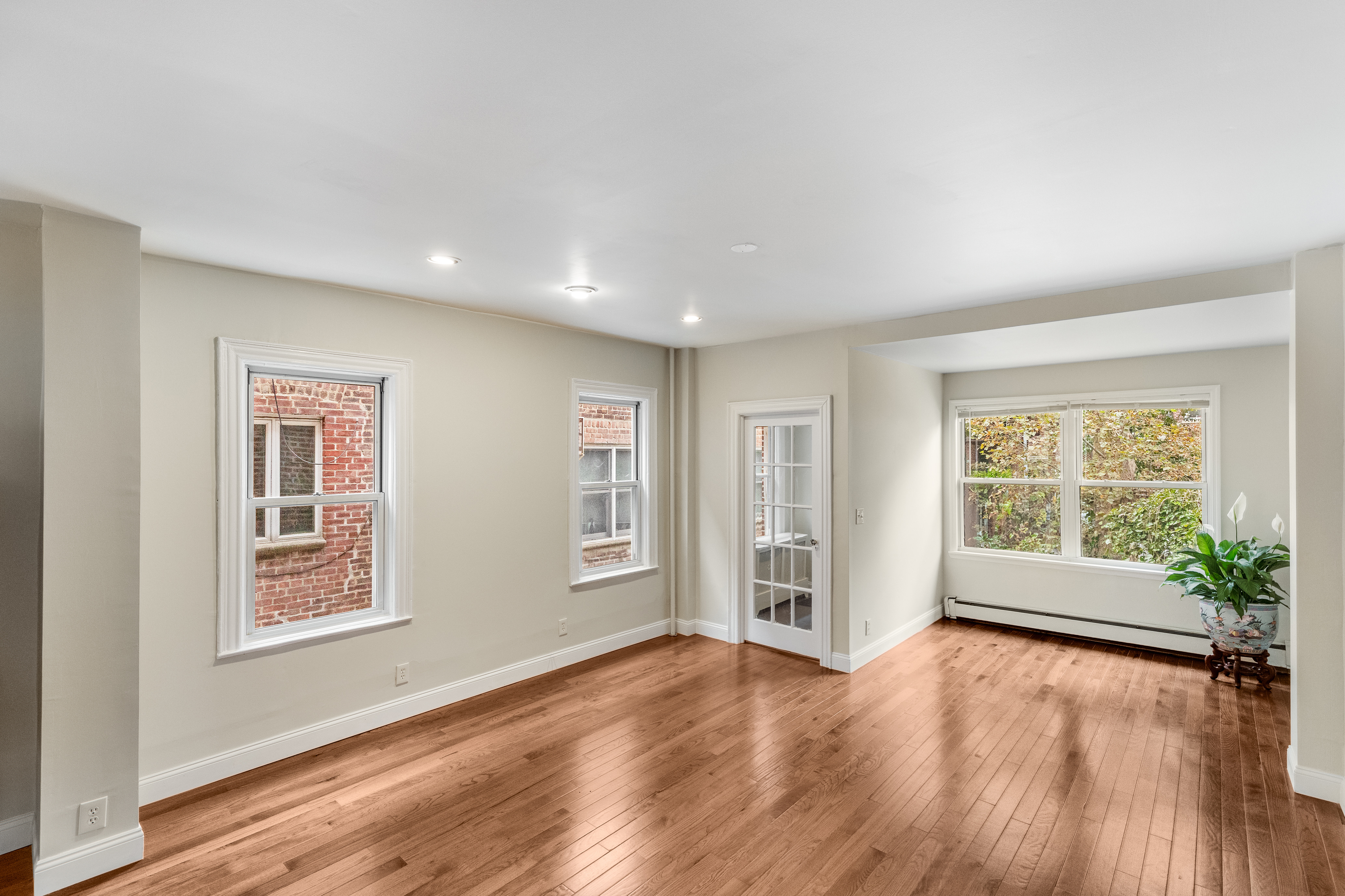 181 Terrace Place Brooklyn, NY 11218 - Photo 4 of 22 a view of an empty room with wooden floor and a window