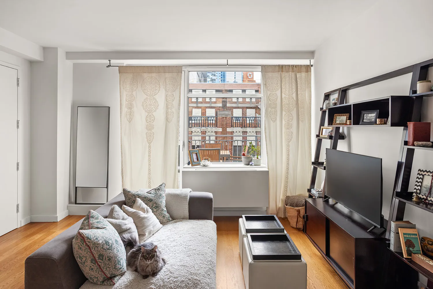 a bedroom with a bed and a flat tv screen on a dresser