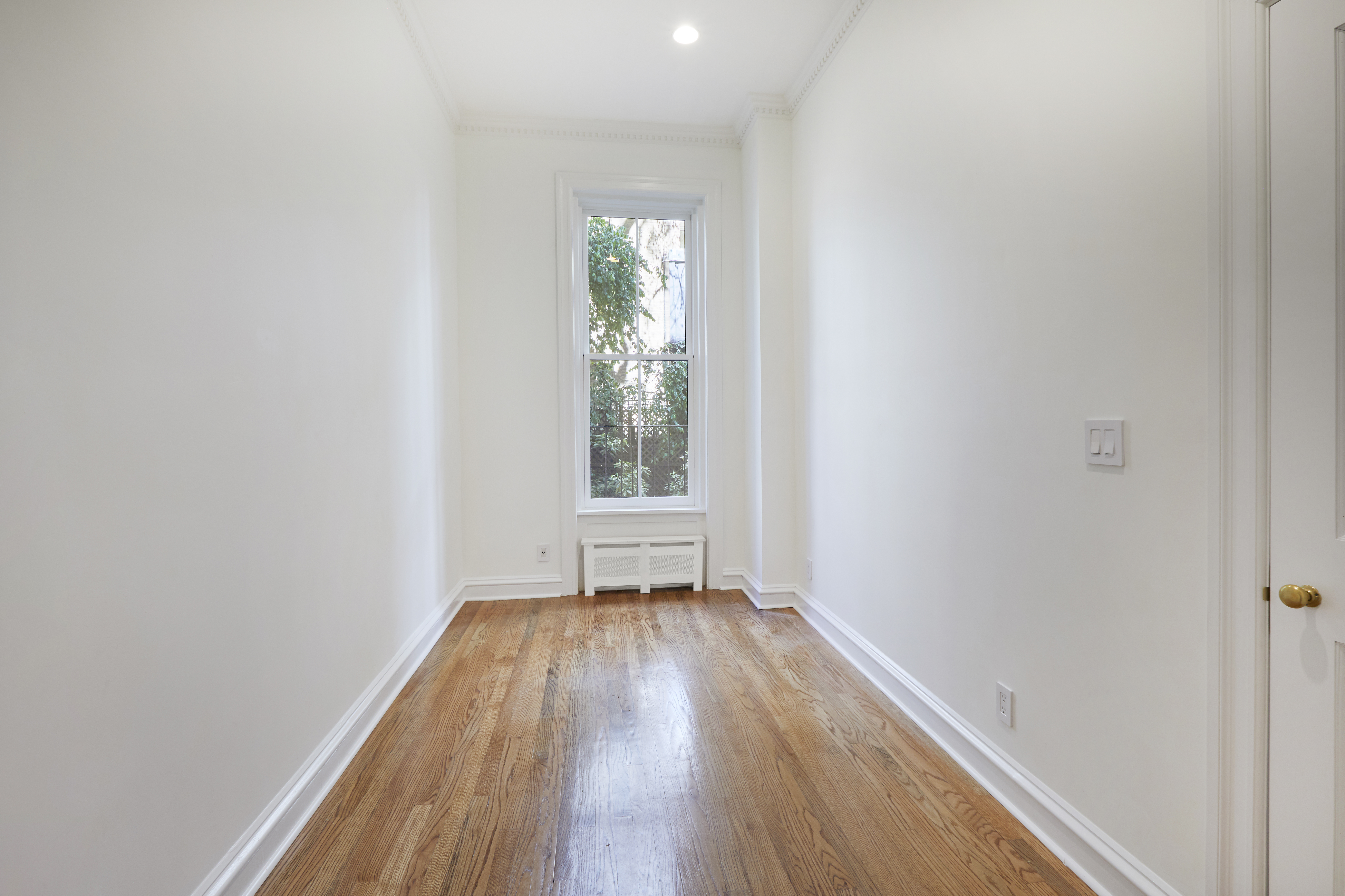 157 East 75th Street, Unit 1E Manhattan, NY 10021 - Photo 17 of 21 a view of an empty room with wooden floor and a window