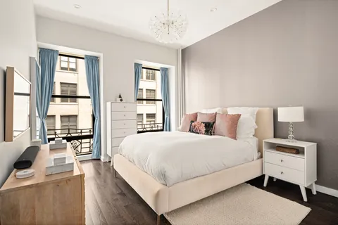 a bedroom with a large bed and a flat tv screen on a dresser