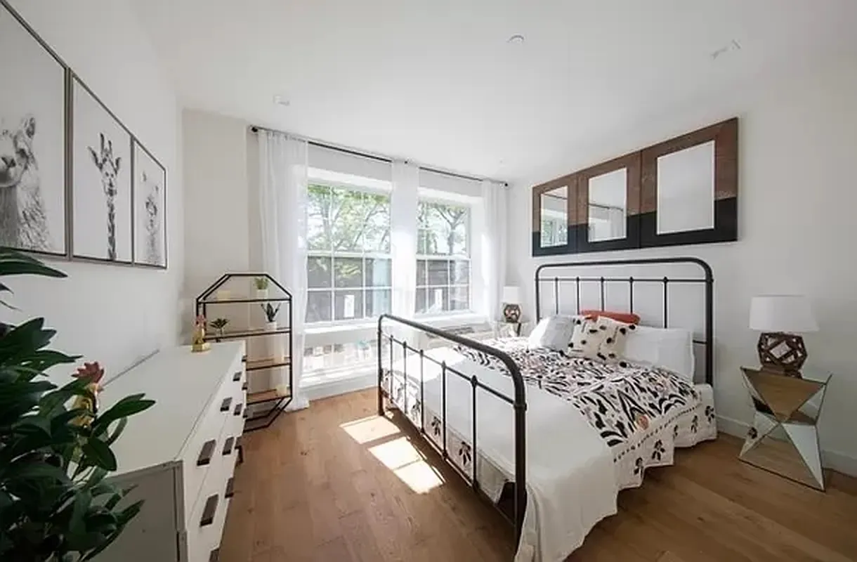 a bedroom with a bed next to a large window with the outer view