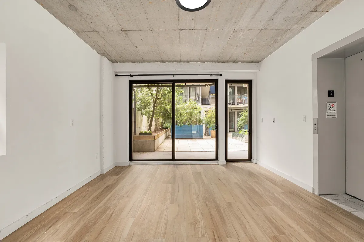 a view of a room with wooden floor and doors